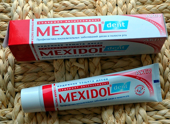 A foto mostra a embalagem e um tubo de creme dental Mexidol Dent Asset.