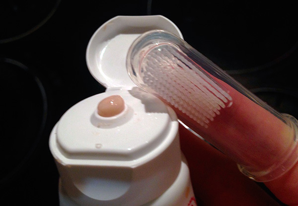 Só é necessário escovar os dentes da criança usando cremes dentais especiais para crianças ou sem pasta de dente no início.